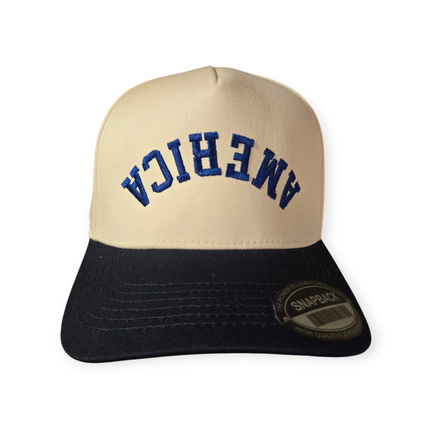 Front facing America Upside Down V1 structured hat in navy blue and beige with the word “America” embroidered upside down in navy blue on the front.