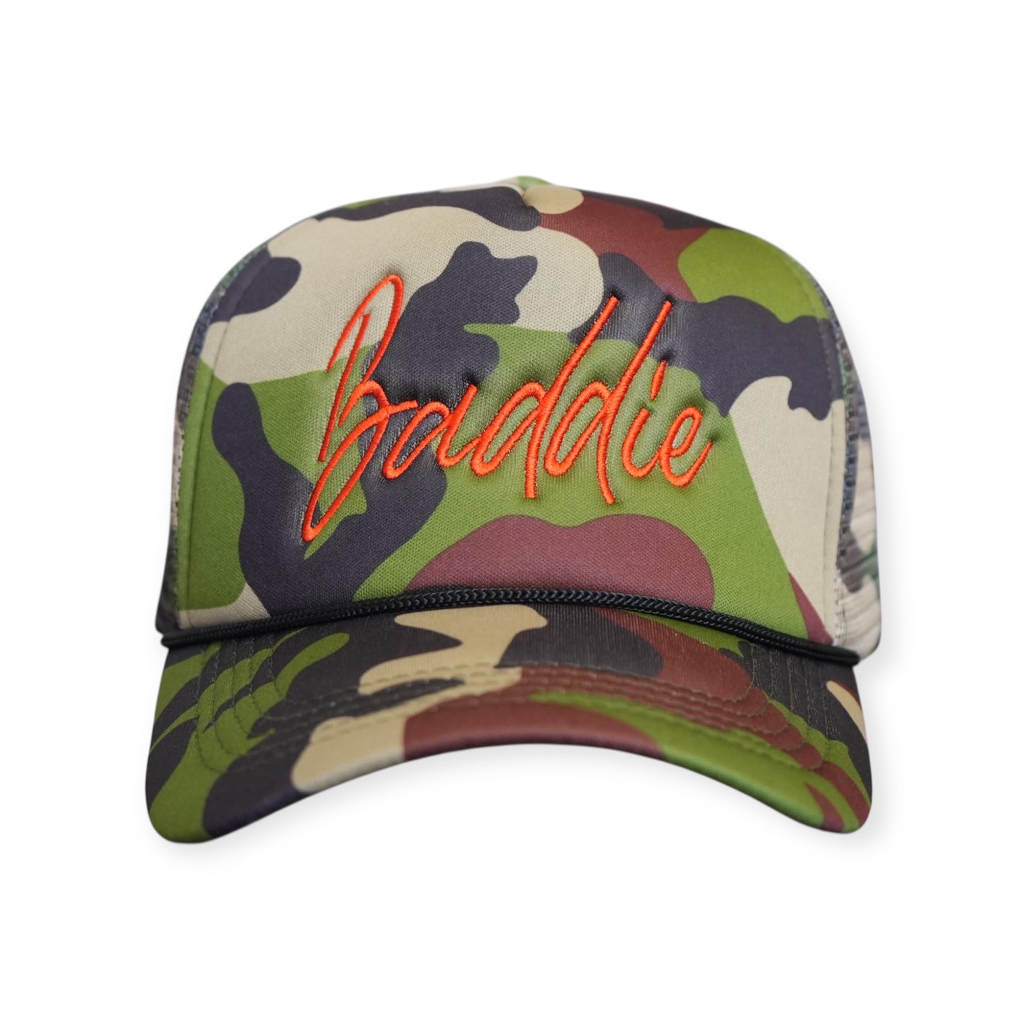 This is a Baddie V1 trucker hat in camouflage with a burnt orange embroidered design on the front panel, facing forward.