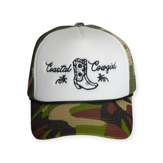 Front-facing Coastal Cowgirl V1 trucker snapback hat with a white front and camo bill, featuring “Coastal Cowgirl” and a western boot embroidered in black.