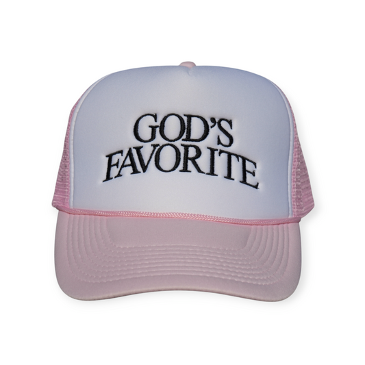 Pink and white polyester trucker snapback hat with a curved brim and “GOD’S FAVORITE” embroidered across the front in black thread.