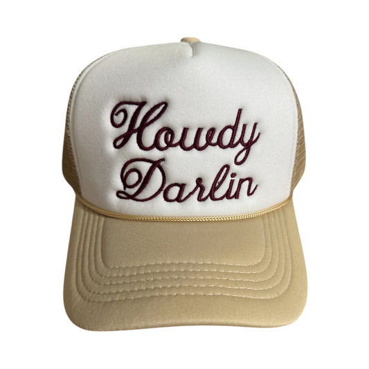 Beige and white trucker hat with “Howdy Darlin” embroidered across the front in burgundy thread